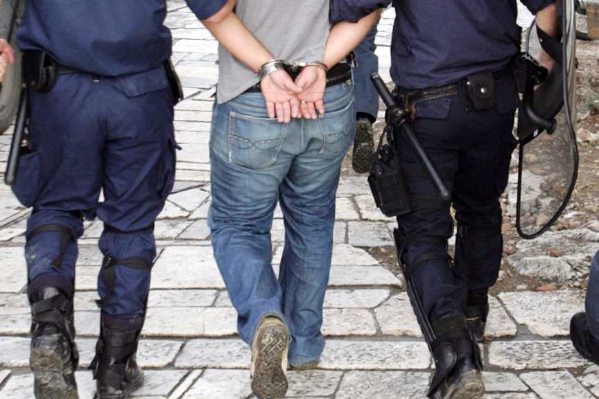 Αστυνομικοί οδηγούν ένα από τους καταληψίες με χειροπέδες στην κλούβα μετά την απώθηση των απεργών συμβασιούχων που είχαν καταλάβει την είσοδο του αρχαιολογικού χώρου της Ακρόπολης, Πέμπτη 14 Οκτωβρίου 2010. ΑΠΕ-ΜΠΕ/ΑΠΕ-ΜΠΕ/ΑΛΕΞΑΝΔΡΟΣ ΜΠΕΛΤΕΣ