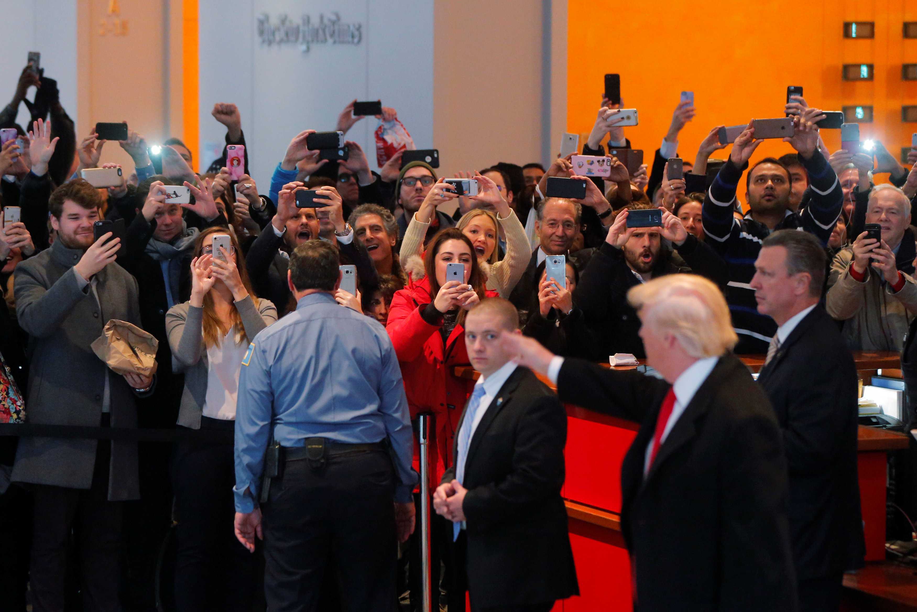 A gathered crowd reacts to U.S. President elect Donald Trump in the lobby of the New York Times building after a meeting in New York, U.S., November 22, 2016. REUTERS/Lucas Jackson